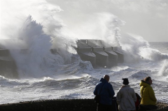 Lidé na snímku v britském Brightonu sledují, jak mohutné vlny naráející do...