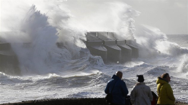 Lidé na snímku v britském Brightonu sledují, jak mohutné vlny naráející do...