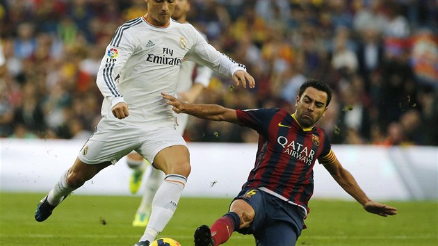 NEPUSTM T KE STELE. Zlonk Barcelony Xavi Hernandez (vpravo) skluzem brn Cristianovi Ronaldovi v centrovn.