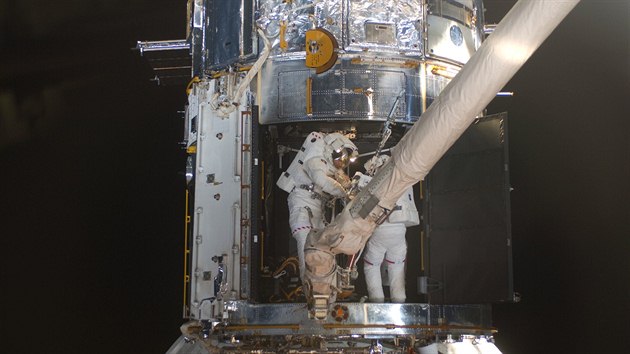 Astronauti Michael Good (vlevo) a Mike Massimino (vpravo) v rmci mise STS-125 opravuj vnitek teleskopu Hubble v kvtnu 2009.