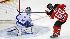 Jaromír Jágr z New Jersey překonává brankáře Bena Bishopa z Tampy Bay. Jaromír Jágr z New Jersey překonává brankáře Bena Bishopa z Tampy Bay.