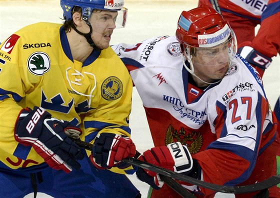 védský hokejista David Ullström (vlevo) se petlauje s ruským reprezentantem...
