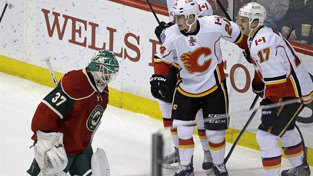 Hokejist Calgary Ji Hudler a Lance Bouma (17) oslavuj gl, sklesl je brank Minnesoty Josh Harding.