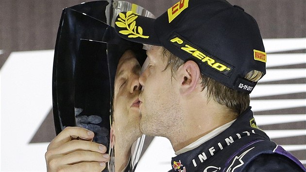 VÍTZNÝ POLIBEK. Sebastian Vettel líbá trofej pro vítze Velké ceny Abú Zabí.