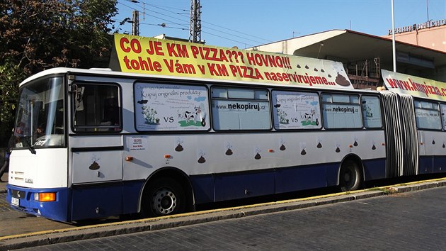Kloubov autobus s vulgrnmi npisy a figurou obence (le za bannerem), kter stl na Smchovskm ndra