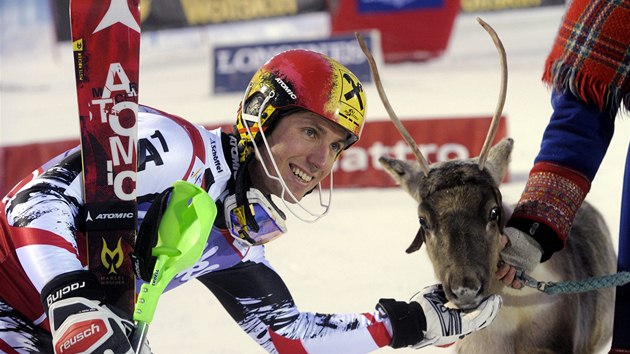 Marcel Hirscher po triumfu ve slalomu v Levi pzuje s tradinm mstnm gratulantem - sobem. 