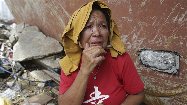 Filipnka, kter peila dn tajfunu, sleduje zkzku u lodi vyvren na sou ve mst Tacloban.