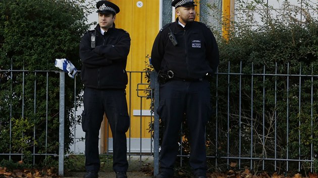 Policist hldkuj ped jednm z dom v londnsk tvrti Lambeth, odkud se podailo osvobodit trojici trznnch en (23. listopadu 2013).
