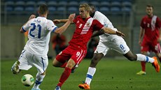 Adam Priestley z Gibraltaru střílí mezi dvojicí bránících slovenských Adam Priestley z Gibraltaru střílí mezi dvojicí bránících slovenských