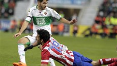 Carles Gil z Elche (v zelenobílém) sleduje, jak Diego Costa padá na zem. Gil má...