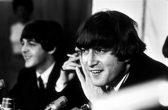 John Lennon na tiskové konferenci v roce 1966, za ním Paul McCartney