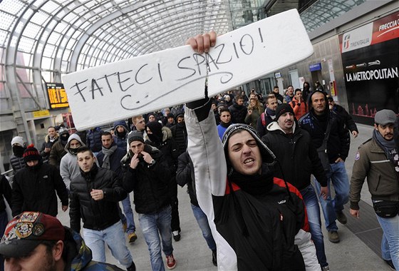 Protesty v italském Turín. Demonstrant drí transparent s nápisem "Dejte nám...