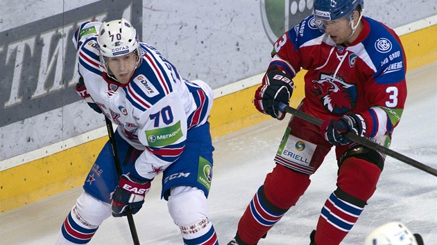 Roman ervenka v dresu Petrohradu (vlevo) kontroluje puk, pijd k nmu Topi Jaakola ze Lva Praha. 