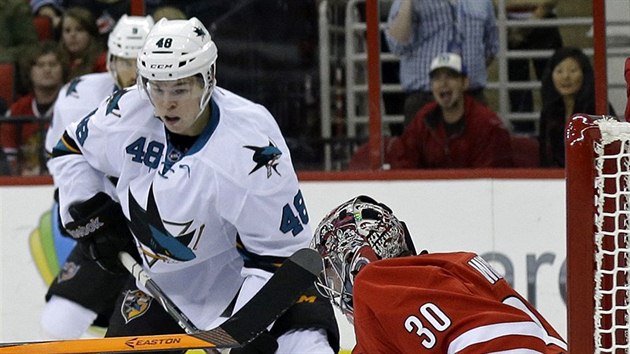 Tom Hertl (48) ze San Jose se tla ped branku Cama Warda z Caroliny.