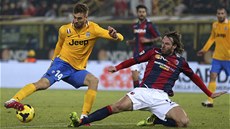 Fernando Llorente z Juventusu Turín zasekl míč, do skluzu jde boloňský obránce Fernando Llorente z Juventusu Turín zasekl míč, do skluzu jde boloňský obránce
