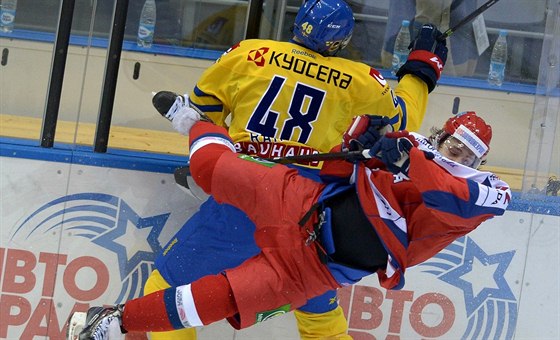 Ruský hokejista Arjom Panarin padá po stetu se védem Danielem Rahimim.