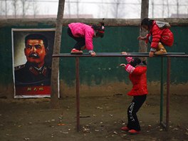 Students play next to a portrait of Soviet leader Joseph Stalin at the...