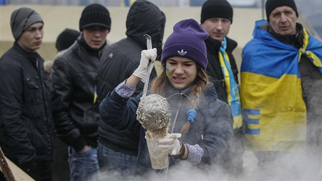 Jedna z demonstrantek v centru Kyjeva pipravuje jdlo, kter je zjemcm k dispozici zdarma (16. prosince 2013).