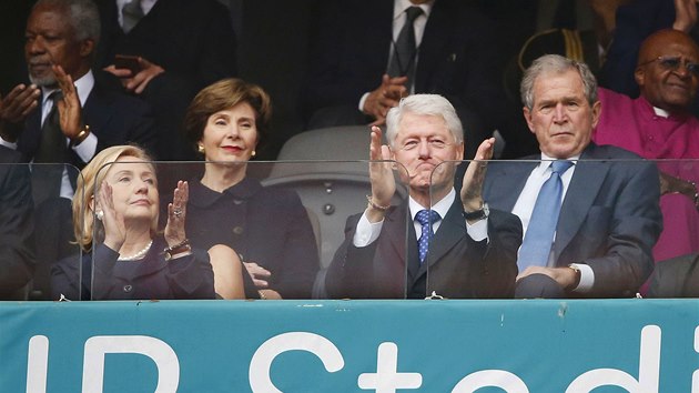 Bval amerit prezidenti Bill Clinton a George W. Bush s manelkami sleduj vzpomnkovou akci na poest zemelho Nelsona Mandely na fotbalovm stadionu v Johannesburgu. (10. prosince 2013)