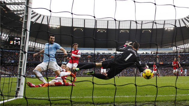 NECHYTIL. Wojciecha Szczesnho, branke Arsenalu, pekonv lvaro Negredo z Manchesteru City (vlevo).