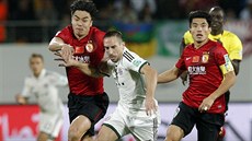 Franck Ribéry proniká mezi Čao Sü-ž'im (vlevo) a Čang Lin-pchengem z týmu... Franck Ribéry proniká mezi Čao Sü-ž'im (vlevo) a Čang Lin-pchengem z týmu...