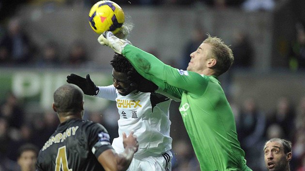 Wilfried Bony (v blm) ze Swansea v souboji s brankem Joem Hartem z Manchesteru City.