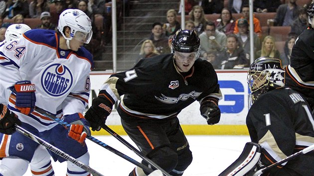 Nail Jakupov (v blm) z Edmontonu se tla k brance Jonse Hillera z Anaheimu, zastavit se ho pokou Cam Fowler.