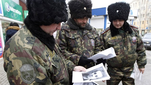 Rut policist prohlej portrty lid podezelch z terorismu (Volgograd, 2. ledna 2014)