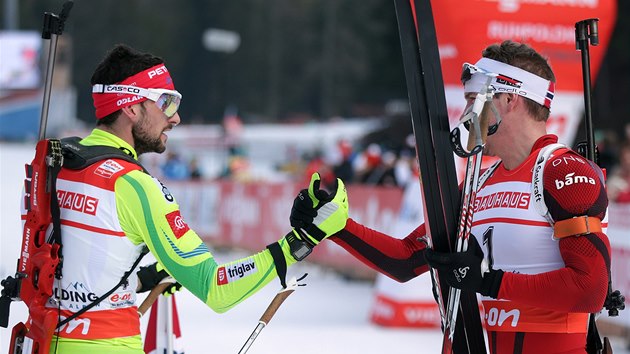 GRATULACE. Vtzn Emil Hegle Svendsen (vpravo) zalamuje palec s druhm Jakovem Fakem  po sthacm zvodu biatlonist v Ruhpoldingu. 