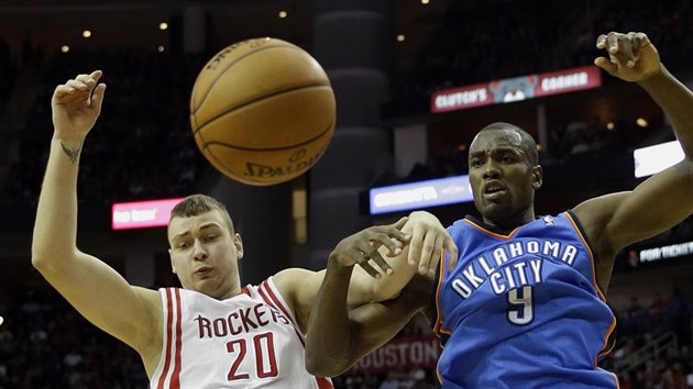 Donatas Motiejunas (vlevo) z Houstonu bojuje o odraen m se Sergem Ibakou z Oklahoma City.