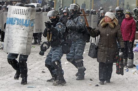 ena v centru Kyjeva drí devený kí, zatímco policisté míí zbranmi na...