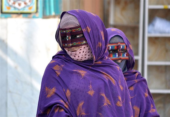 Bandar Abbás. eny s typickou obliejovou maskou na bazaru
