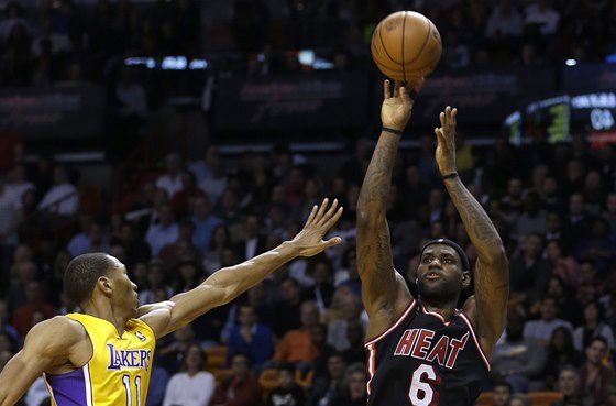 LeBron James z Miami stílí, brání ho Wesley Johnson z Los Angeles Lakers. 