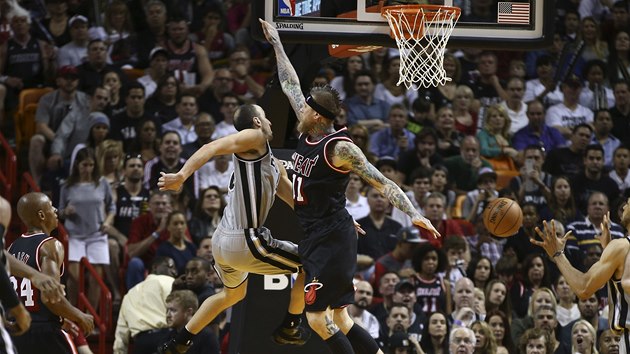 SOUBOJ VE VZDUCHU. Pod koem na sebe narazili  Chris Andersen (v tmavm) z Miami a Manu Ginobili ze San Antonia.