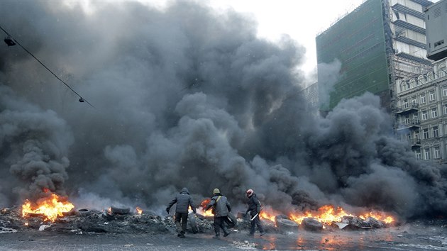 Demonstranti zaplili v ulicch Kyjeva barikdy z pneumatik. (23. ledna 2014)
