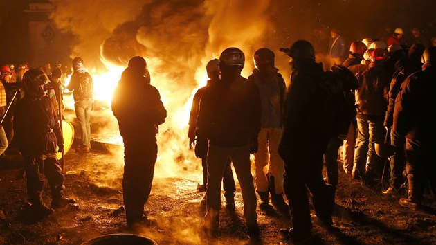 Demonstrant se ohvaj u jedn z barikd v centru Kyjeva. (24. ledna 2014)