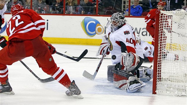 Manny Malhotra z Caroliny stl gl do st Ottawy, jej glman Robin Lehner je proti stele bezmocn.