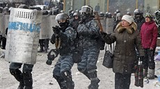 ena v centru Kyjeva drí devený kí, zatímco policisté míí zbranmi na...