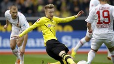 Marco Reus z Dortmundu (ve lutém) v boji o balón bhem duelu proti Augsburgu