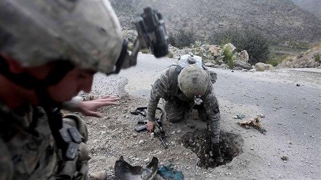 Amerit vojci v Afghnistnu opatrn odstrauj zbytky vbuniny, kterou na silnici nastrail Taliban.