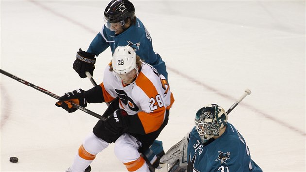 Claude Giroux (v blm) z Philadelphie se sna prodrat pes brncho Brada Stuarta ze San Jose ped glmana Anttiho Niemiho.