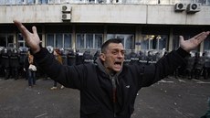 Muž v bosenské Tuzle se obrací k demonstrantům, aby přestali házet kameny na... Muž v bosenské Tuzle se obrací k demonstrantům, aby přestali házet kameny na...