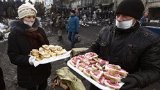 Protivládním demonstrantm v centru Kyjeva nosí dobrovolníci na barikády...