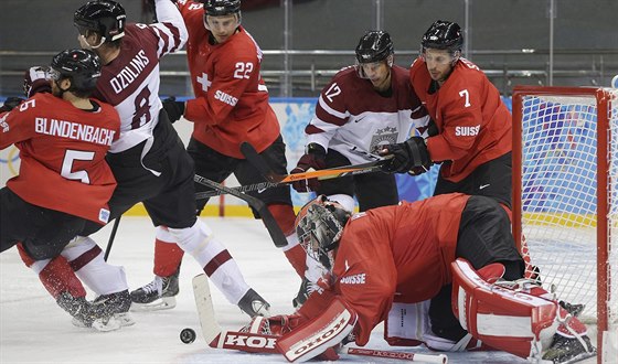 SKRUMÁ. výcarský gólman Jonas Hiller se v duelu s Lotyskem snaí zkrotit puk.