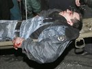 Opoziní demonstranté pomáhají policistovi zrannému bhem noních stet v...