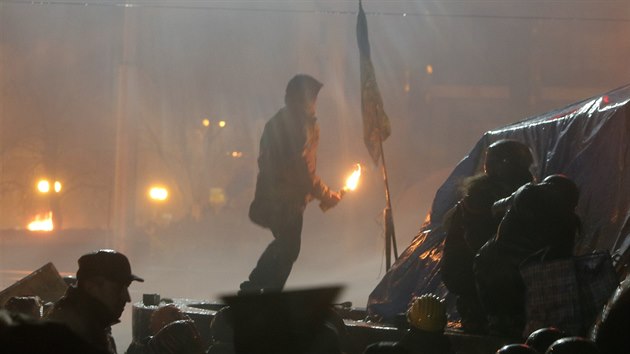 Demonstranti zapalovali pneumatiky, aby zabrnili policistm v postupu smrem k tboru a na leny bezpenostnch sloek hzeli i zpaln lahve (18. nora)
