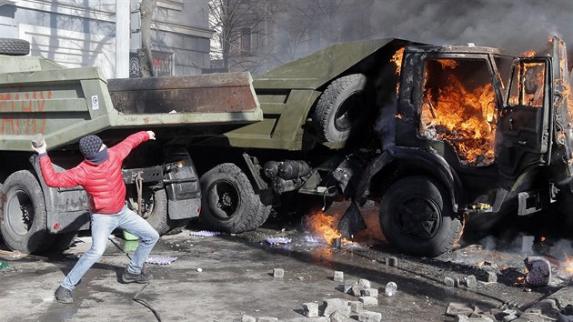 Jeden z opozinch demonstrant hz dlaebn kostku smrem k policistm. (18. nora 2014)