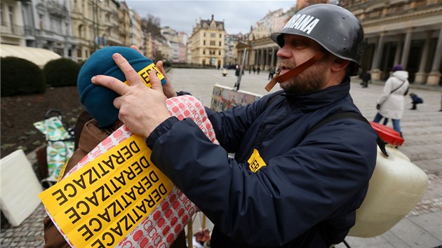 Happening karlovarskho opozinho zastupitele Jiho Kotka (v helm), aneb Deratizace kolondy buskingem. Prv lep npis deratizace na epici malky Doris Windlin.