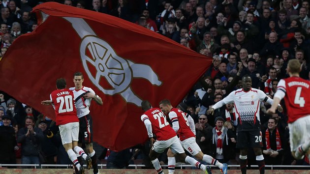 ODPLATA SE DA. Fotbalist Arsenalu se raduj z glu Lukase Podolskho (uprosted) proti Liverpoolu.