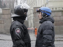 Dva svty. Policejn tkoodnec a protivldn demonstrant v lyask pilb.